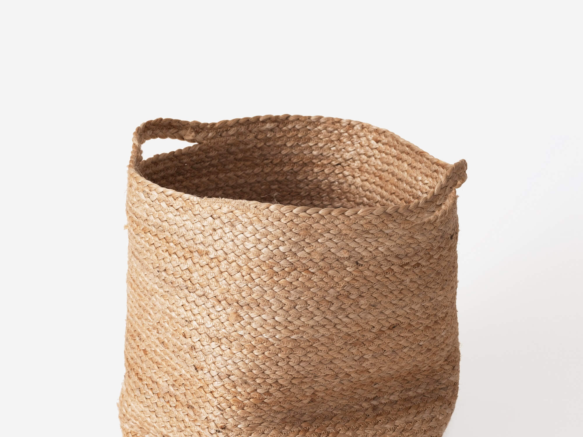 Front view of woven braided laundry basket with throw in it